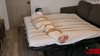 www.cinchedandsecured.com - 1344 - Mia and Bri - Gagged, Wrapped, Roped and Foot Rubbed thumbnail